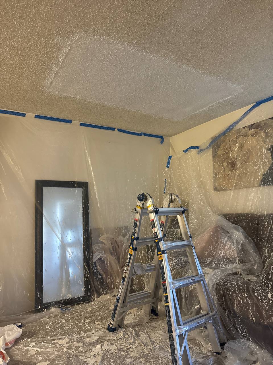 Room protected with plastic sheeting during ceiling work